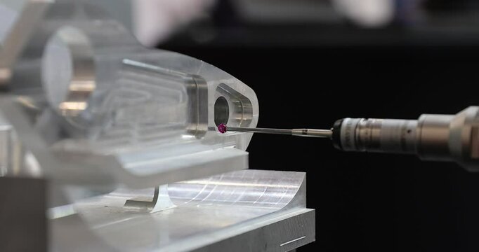 Slow motion 4k movie of a computerized measurement and control device of the dimensions of a metal engine block part with a probe stylus ball tip of multi-axis coordinate measuring machine.