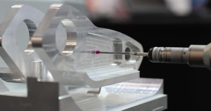 Slow motion 4k movie of a computerized measurement and control device of the dimensions of a metal engine block part with a probe stylus ball tip of multi-axis coordinate measuring machine.