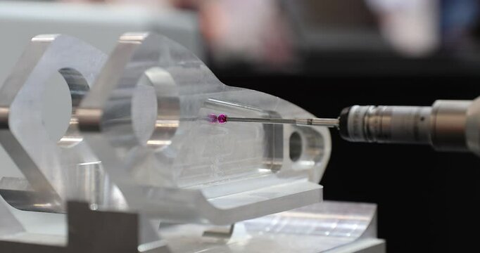 Slow motion 4k movie of a computerized measurement and control device of the dimensions of a metal engine block part with a probe stylus ball tip of multi-axis coordinate measuring machine.