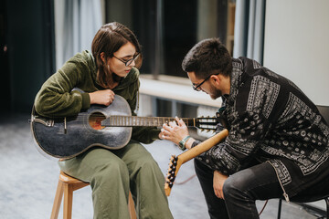 A man and a woman engage in a guitar session, learning and sharing techniques in a professional studio setting. The environment emphasizes collaboration, music creation, and artistic expression.