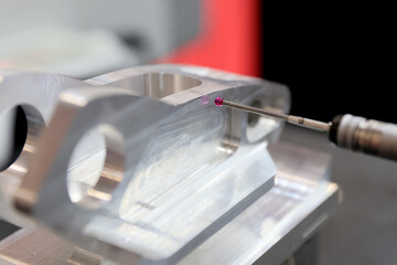Computerized measurement and control device of the dimensions of a metal engine block part with a probe stylus ball tip of multi-axis coordinate measuring machine.