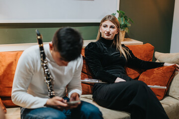 Two musicians unwind in a cozy living room setting, their instruments nearby, conveying creativity...
