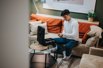 A young man in casual attire arranging accessories in a relaxing, creatively inspiring home...