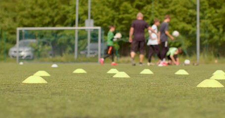 The youth soccer training program enhances young players skills using strategically placed cones. Enthusiastic players practice under the guidance of their knowledgeable coach
