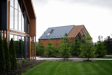 Obraz premium Modern wooden houses surrounded by lush greenery and well-maintained landscaping