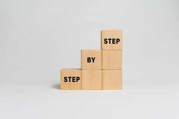 step by step word on wooden blocks staircase isolated on white background. concept of success progress or career