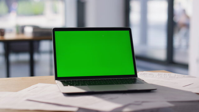 Chroma key laptop placed on modern workspace closeup. Green screen computer