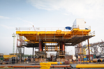 Oil rig under construction onshore. To assemble steel structure platform by lifting , technology engineering. Heavy industry for exploration and drilling for crude oil resources and natural gas.