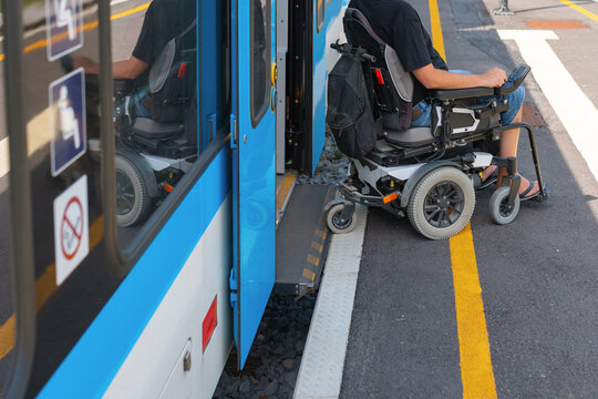 Man with disability uses a wheelchair to board a train. - Powered by Adobe