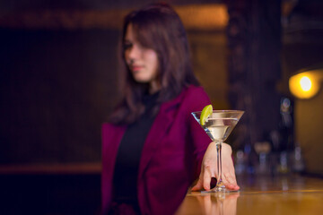 Beautiful girl drinks a cocktail at the bar