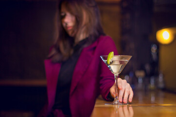 Beautiful girl drinks a cocktail at the bar