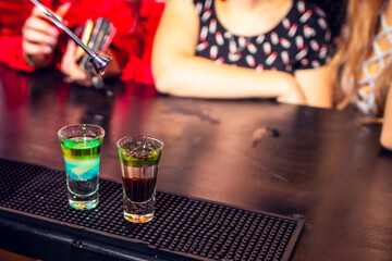 two glasses with a cocktail on the bar