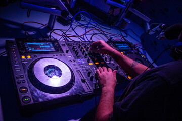 Dj mixes the track in nightclub at party