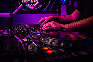 Dj mixes the track in nightclub at party