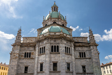 Historic Stone Cathedral with Green Dome and Cloudy Blue Sky Background