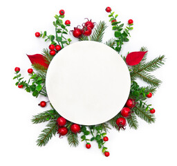 Christmas decoration. Branch christmas tree, red berries, red leaves poinsettia with white paper card note with space for text on white background. Top view, flat lay