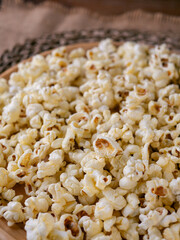 Butter salted popcorn on wooden table.