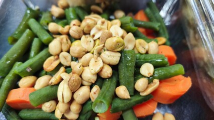 A healthy and delicious lunch meal with green beans, carrots, peanuts, and omelette