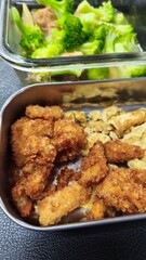 Close-up of fried food and scrambled eggs in a metal tray