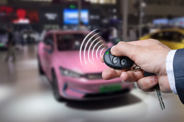 Men's hand presses on the remote control car alarm systems.