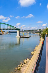 Heavy machinery removing historic bridge with Belgrade old town behind