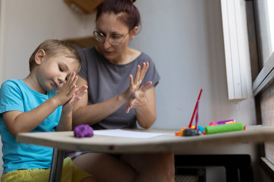 Mother and son playing with modeling clay at home