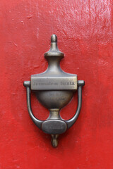 Brass door knocker on a red door at the entrance to Jerusalem Santa's House in the Christian...