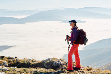 A female mountaineer, equipped with professional gear, enjoys the thrill of her climb as she...