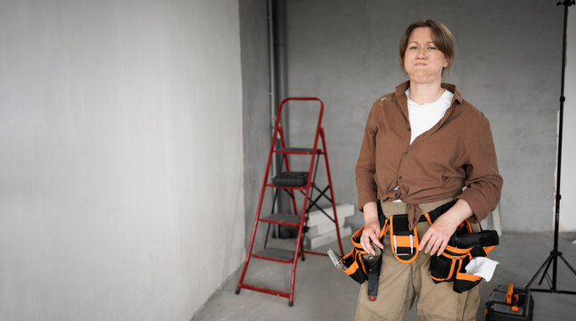 Young repairwoman doing a home renovation pouting her cheeks, doesnt want to share information looking at camera