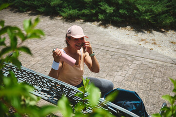Smiling Woman Resting on Bench Outdoors After a Workout Session