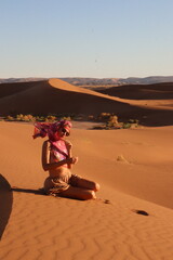 Beautiful woman in the dunes of the desert