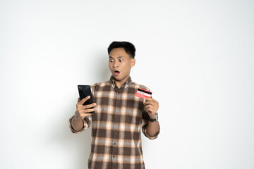 A man with a surprised expression holds a credit card and smartphone, showcasing emotion and modern lifestyle.
