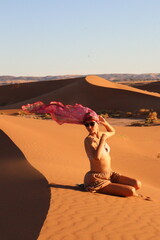 Beautiful woman in the dunes of the desert