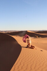 Beautiful woman in the dunes of the desert