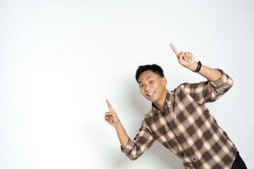 A cheerful Asian man in a checkered shirt points upward against a plain white backdrop, expressing enthusiasm and positivity.