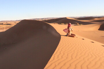 Beautiful woman in the dunes of the desert