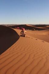 Woman doing yoga pose in the desert dunes