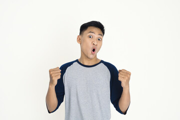 A young man expressing excitement and joy with clenched fists and a vivid facial expression, wearing casual clothing, demonstrating positive emotion, celebration, and personal achievement