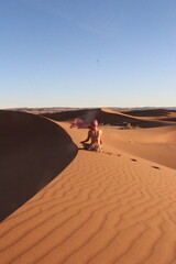 Woman doing yoga pose in the desert dunes