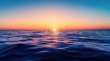 Obraz premium A sunset-lit empty deep sea with soft orange and purple tones reflecting on calm open water