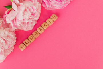 Congrats message with pink peonies on vibrant pink background. Copy space
