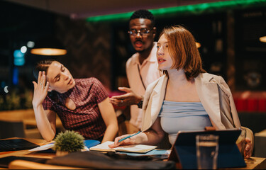Young professionals from diverse backgrounds discuss ideas and collaborate in a high-energy late...