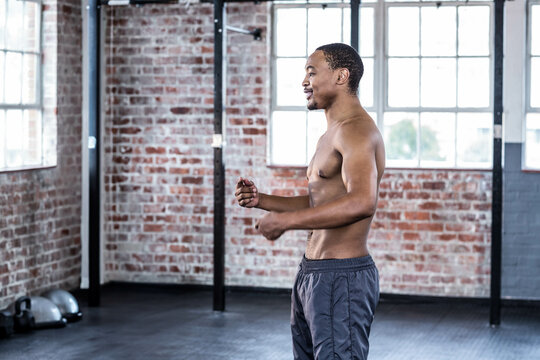 African American man assuming stance in warehouse gym with balance trainers, windows, copy space