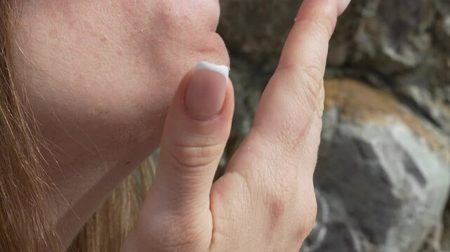 Skin face rock, summer day: woman poses, age 18plus sign on the rock outdoor.