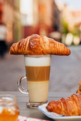 Fragrant croissant breakfast in a cozy old town on the summer terrace of an atmospheric cafe in...