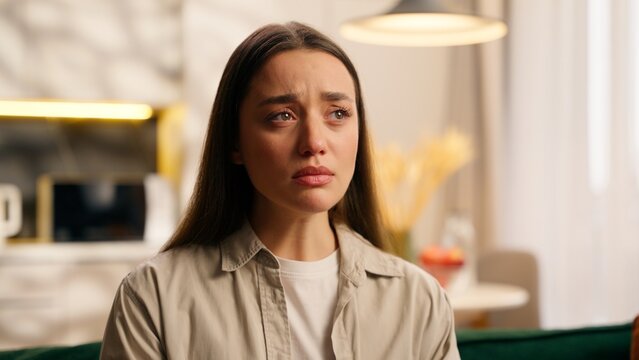 Portrait upset sad Caucasian woman girl female crying suffering despair at home feeling unhappy bad depressed stressful break up failure cry emotion loss relationship unwanted pregnancy in living room