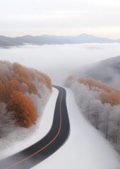 Serene road winding through autumn and winter forest with misty mountain view