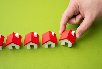 Hand lining up houses. Realtor or real estate developer. Selling a house. Property selection, real...