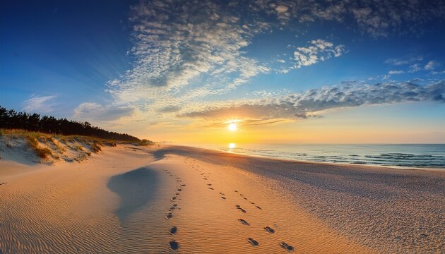 wonderful summer sunrise on baltic sea with the end of the sand spit with a lots of footsteps amazing endless clouds in blue sky picturesque morning scene of rewa public beach poland europe