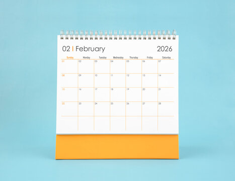 February 2026 white desk calendar on blue color background. Planning and goals concepts. - Powered by Adobe